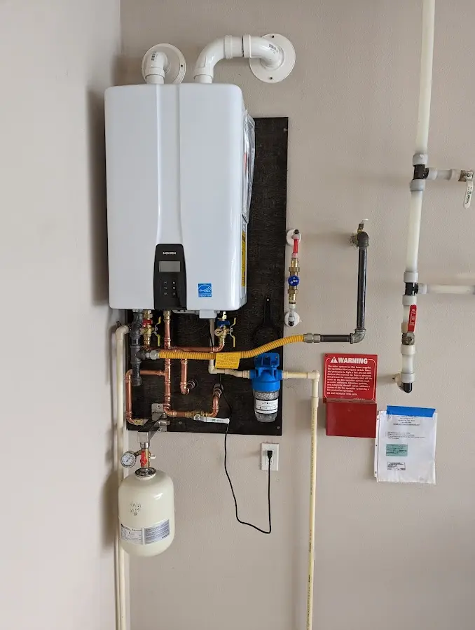 Professional plumber installing copper piping in a Boscawen home